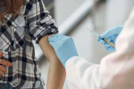 Eine Junge Frau bekommt eine Impfung mit einer Spritze